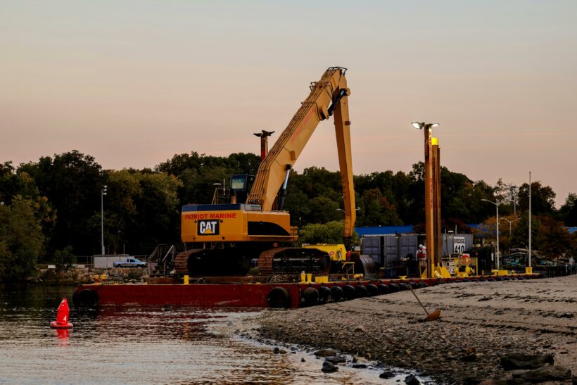 Dredging using excavators to remove sediments from waterbed